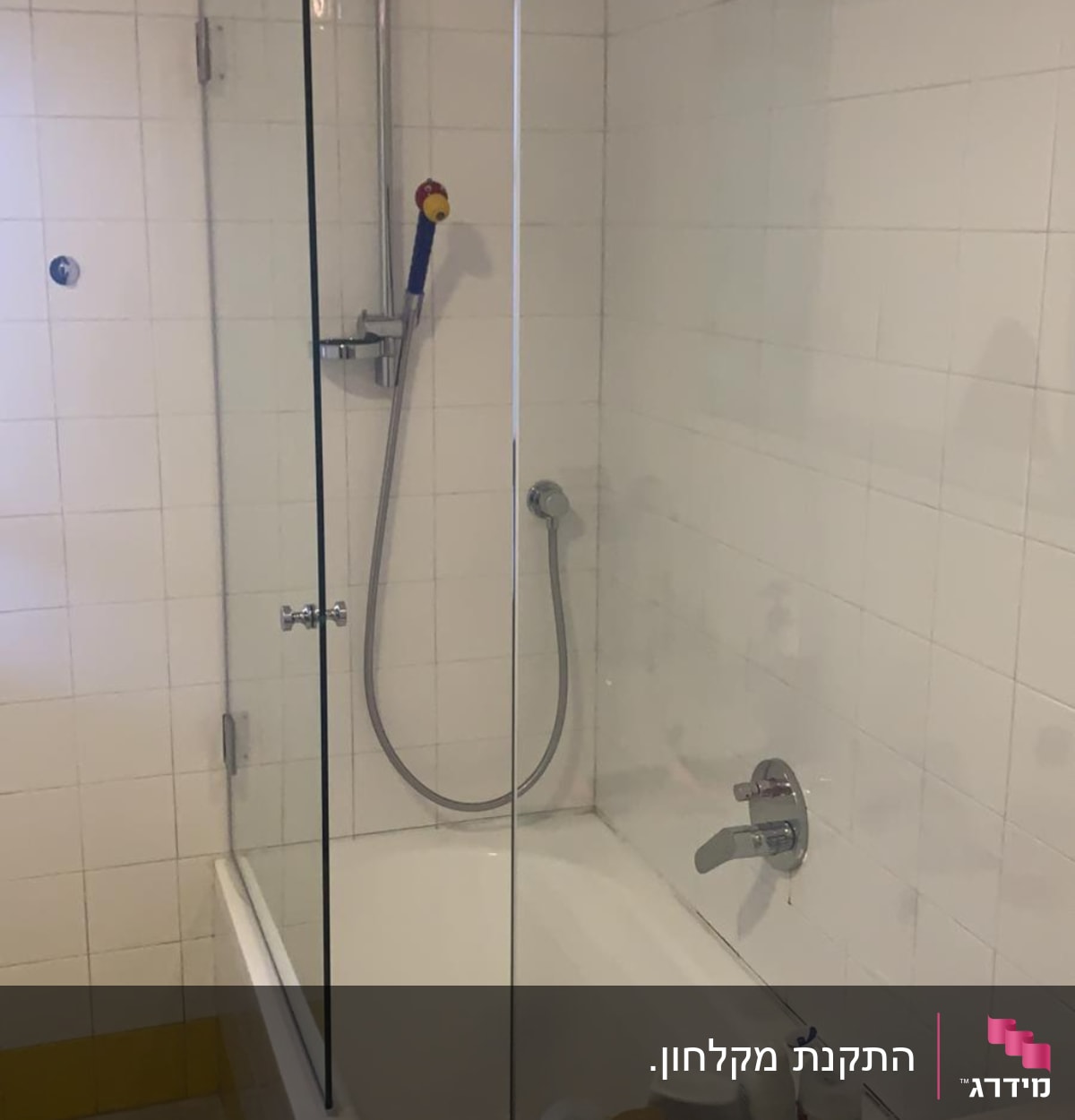 מקלחת עם דלת זכוכית, ראש מקלחת ומוצרים על מדף